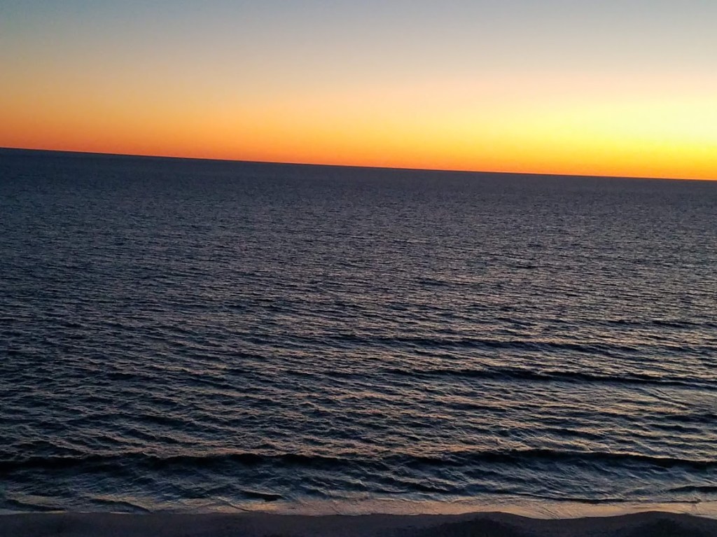 Orange winter sunset fading over the dark Gulf of Mexico